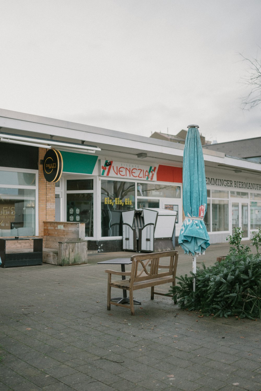 a wooden bench sitting in front of a store