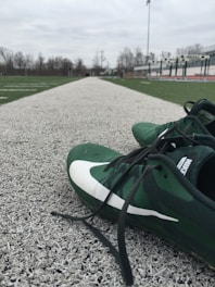 A pair of sleek running shoes with bright laces on a track field.