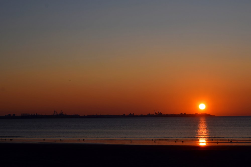 the sun is setting over a body of water