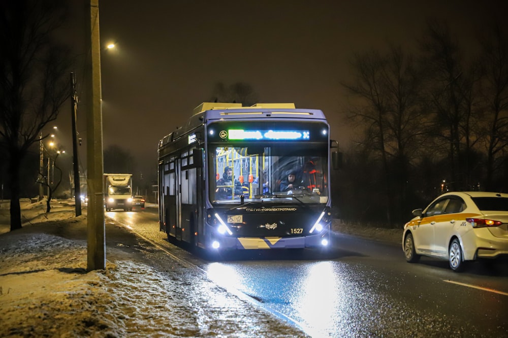 a bus driving down a street at night
