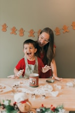 a woman and a child are making christmas cookies