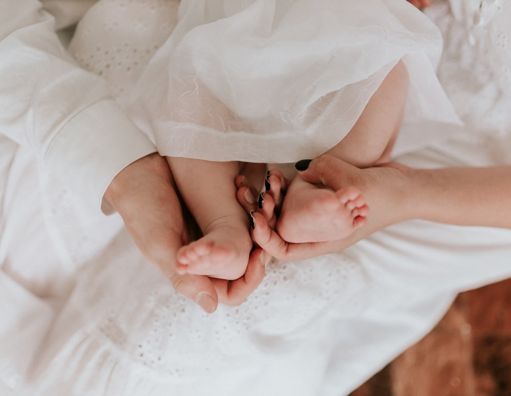 a woman in a white dress laying on a bed