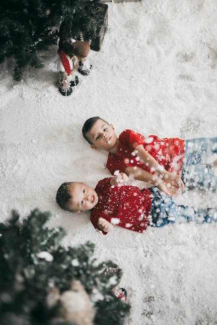 Children playing in a snowy environment, surrounded by Christmas decorations.