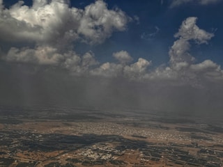 A sweeping aerial view of vast Texas farmland under a cloudy sky, emphasizing scale and story.