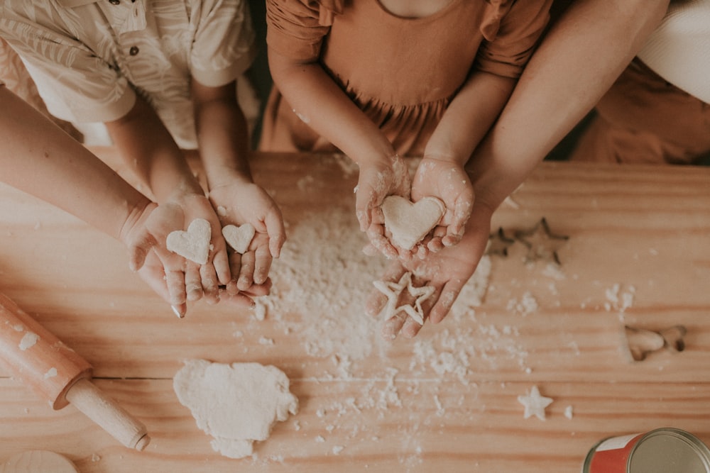 a group of people making heart shaped cookies