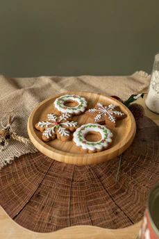 Close-up of beautifully decorated cookies with pastel colors and intricate designs on a rustic wooden table.