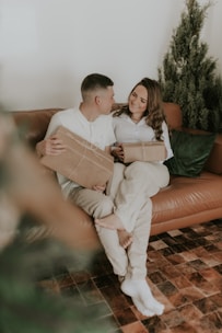 A couple exchanging personalized gifts in a warm, cozy setting.