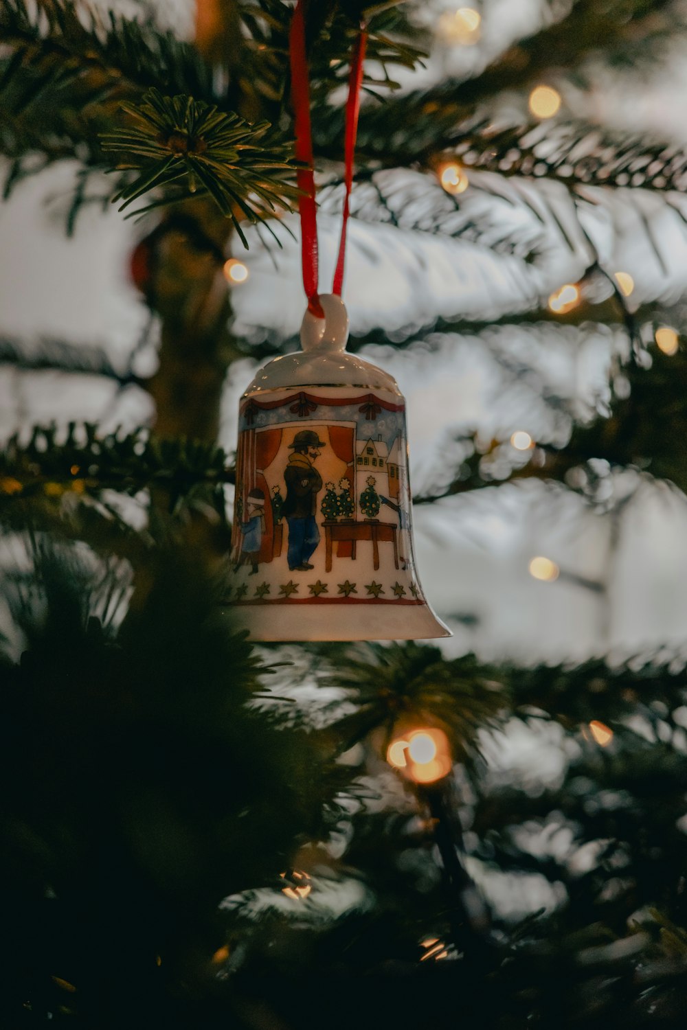a bell ornament hanging from a christmas tree