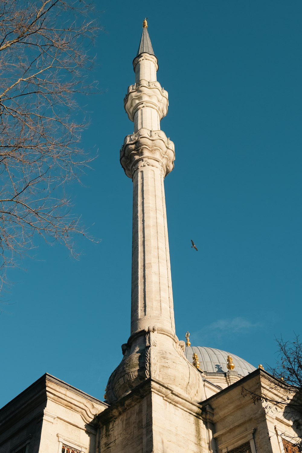 a tall white tower with a clock on it's side