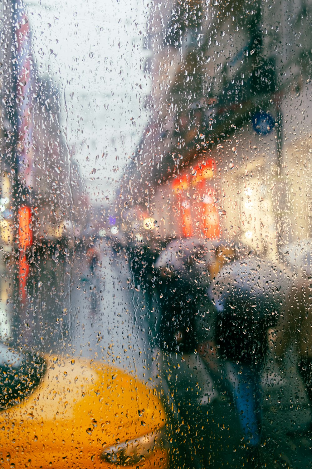 a view of a city street through a rain covered window