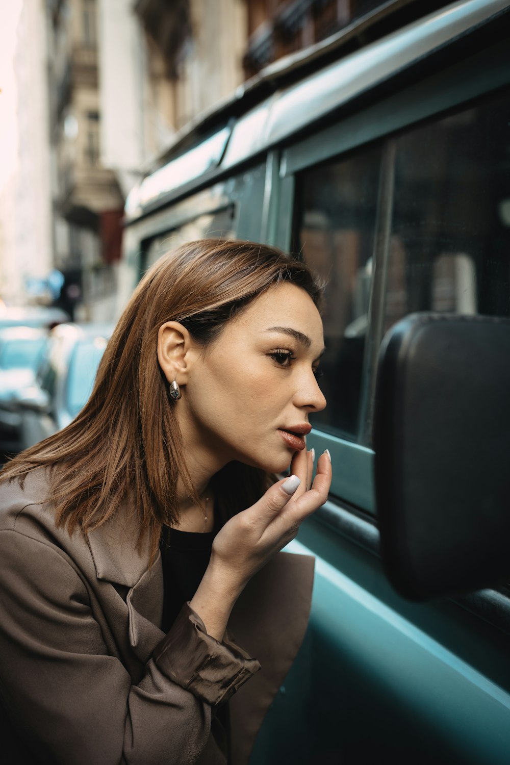 a woman smoking a cigarette next to a car