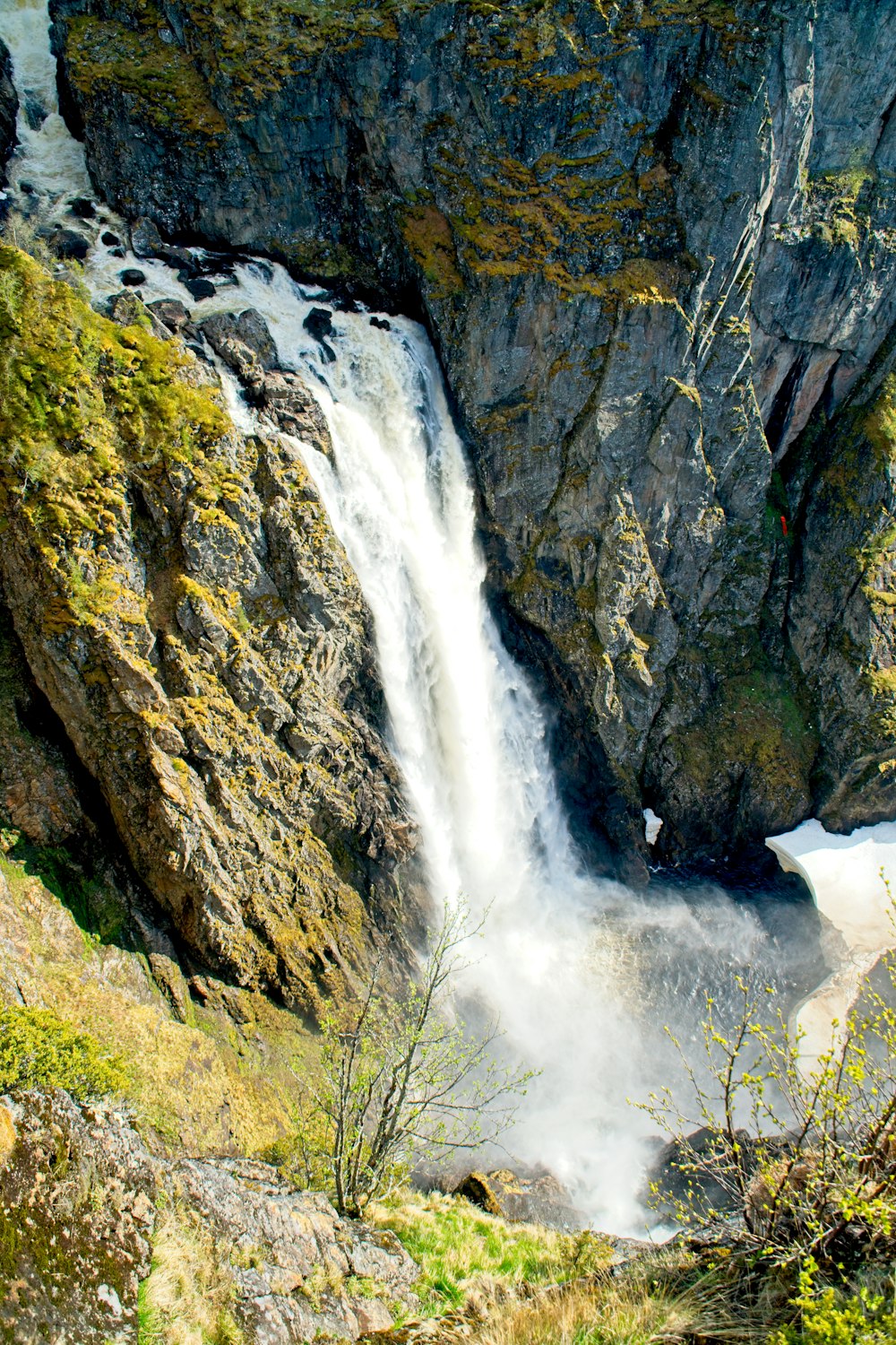 a large waterfall is coming out of the side of a mountain