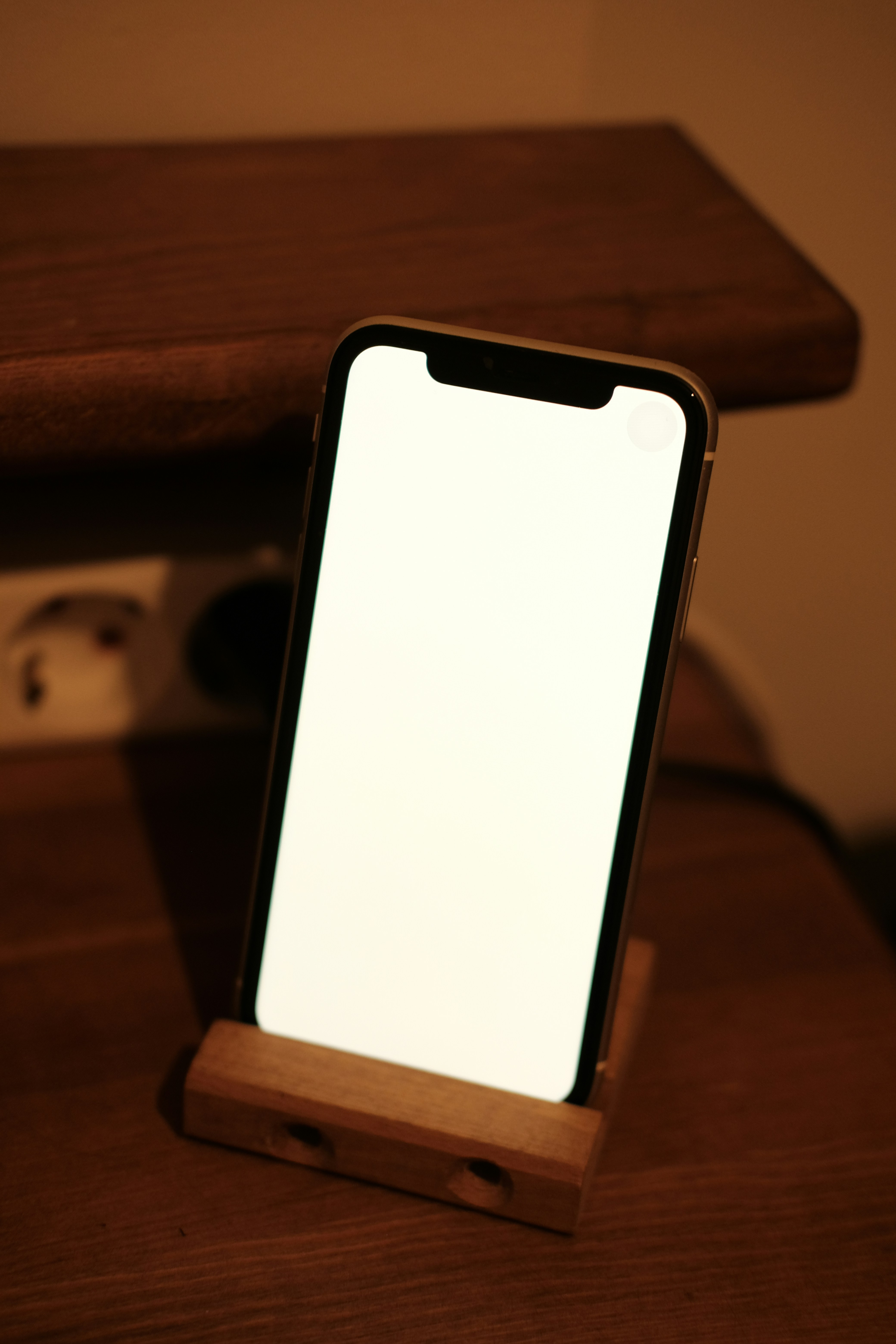 a cell phone sitting on top of a wooden stand