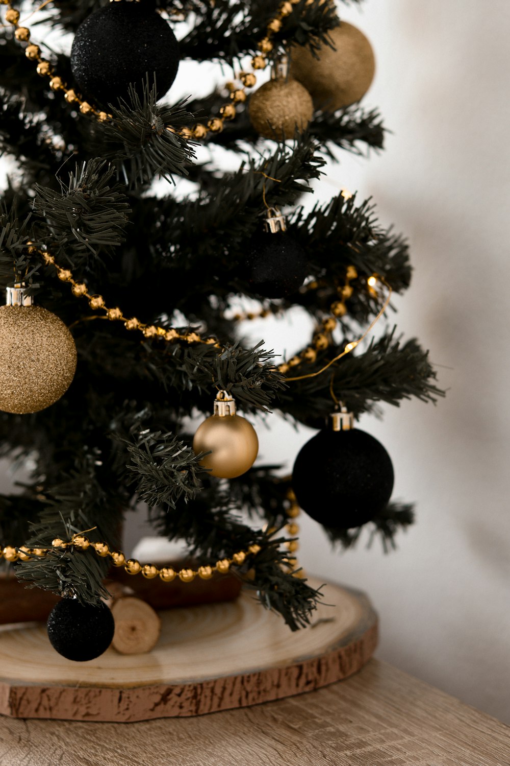 a small christmas tree with black and gold ornaments