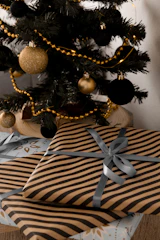 Festive corporate hampers with eco-friendly gifts and custom branding, arranged with silver and black ribbons.