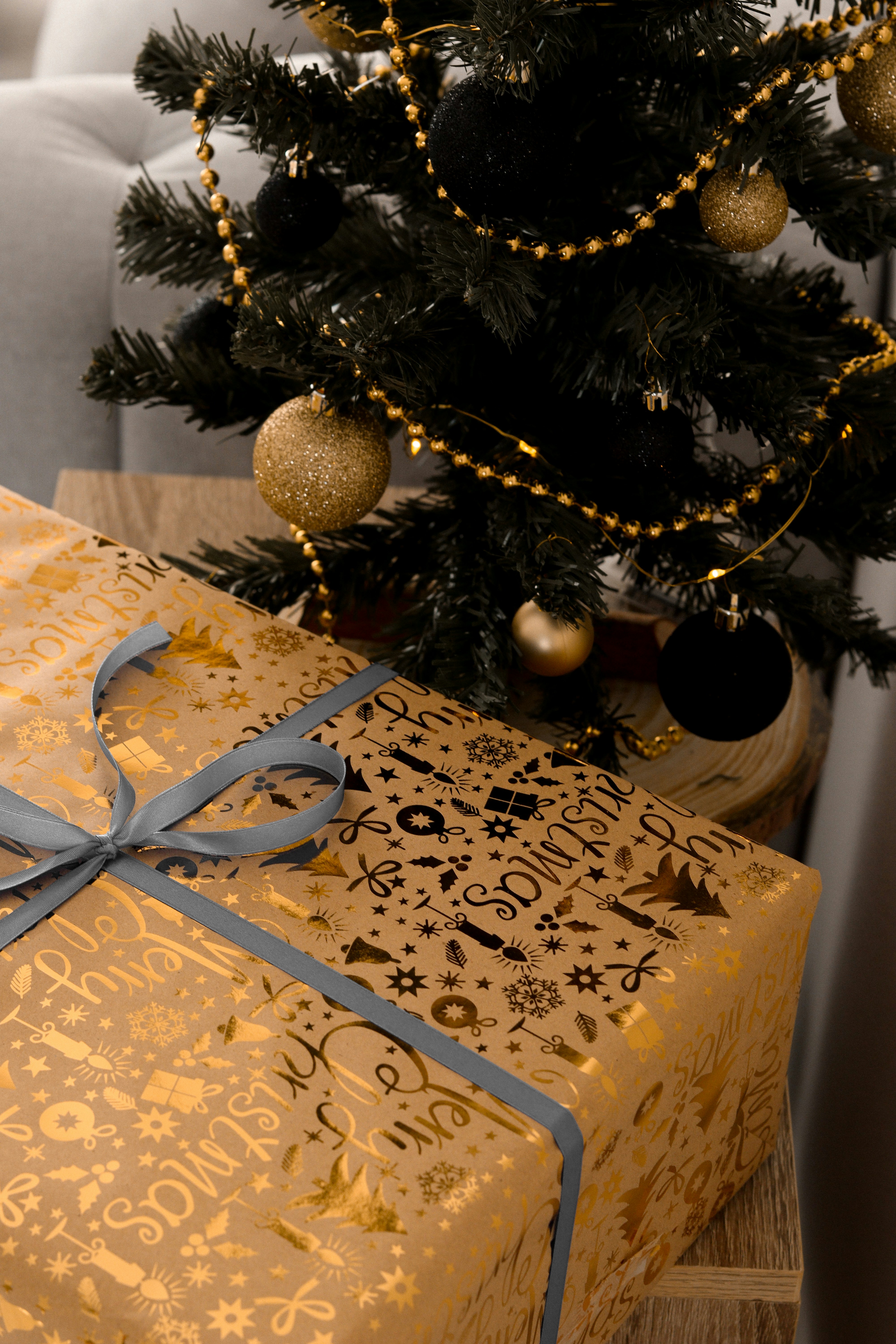 a wrapped christmas present under a christmas tree