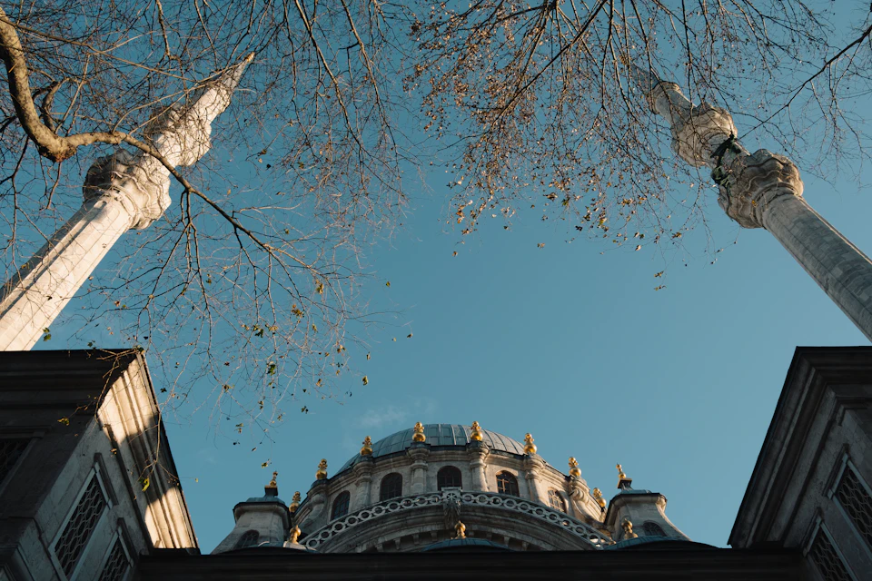 Majestic mosque with two towering minarets standing tall in front of clear blue sky