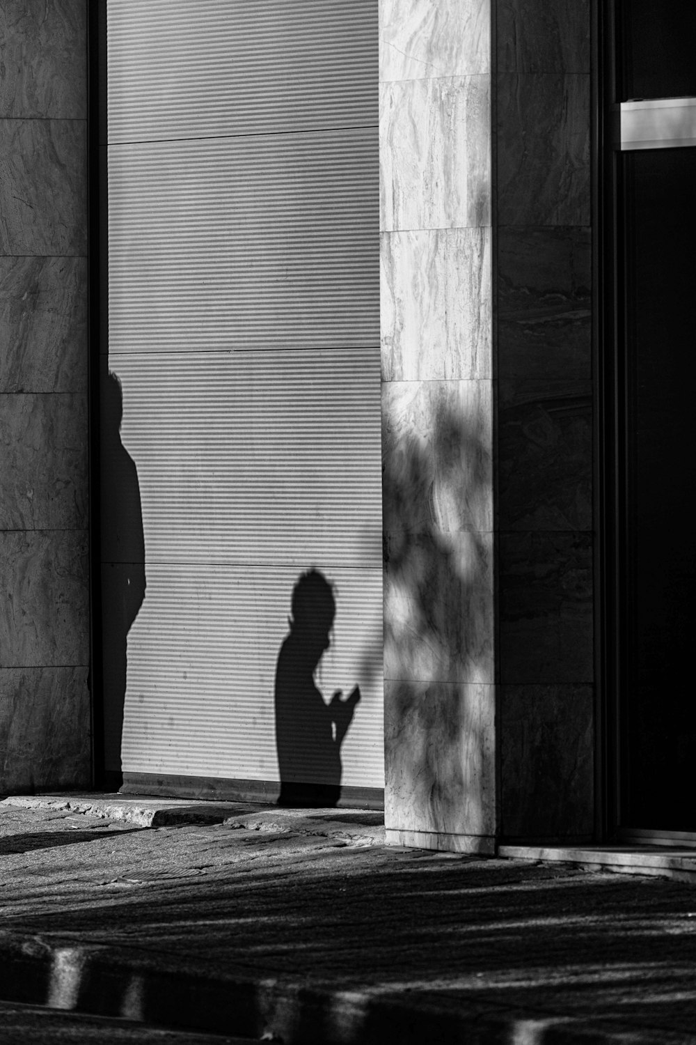 a shadow of a person standing in front of a building