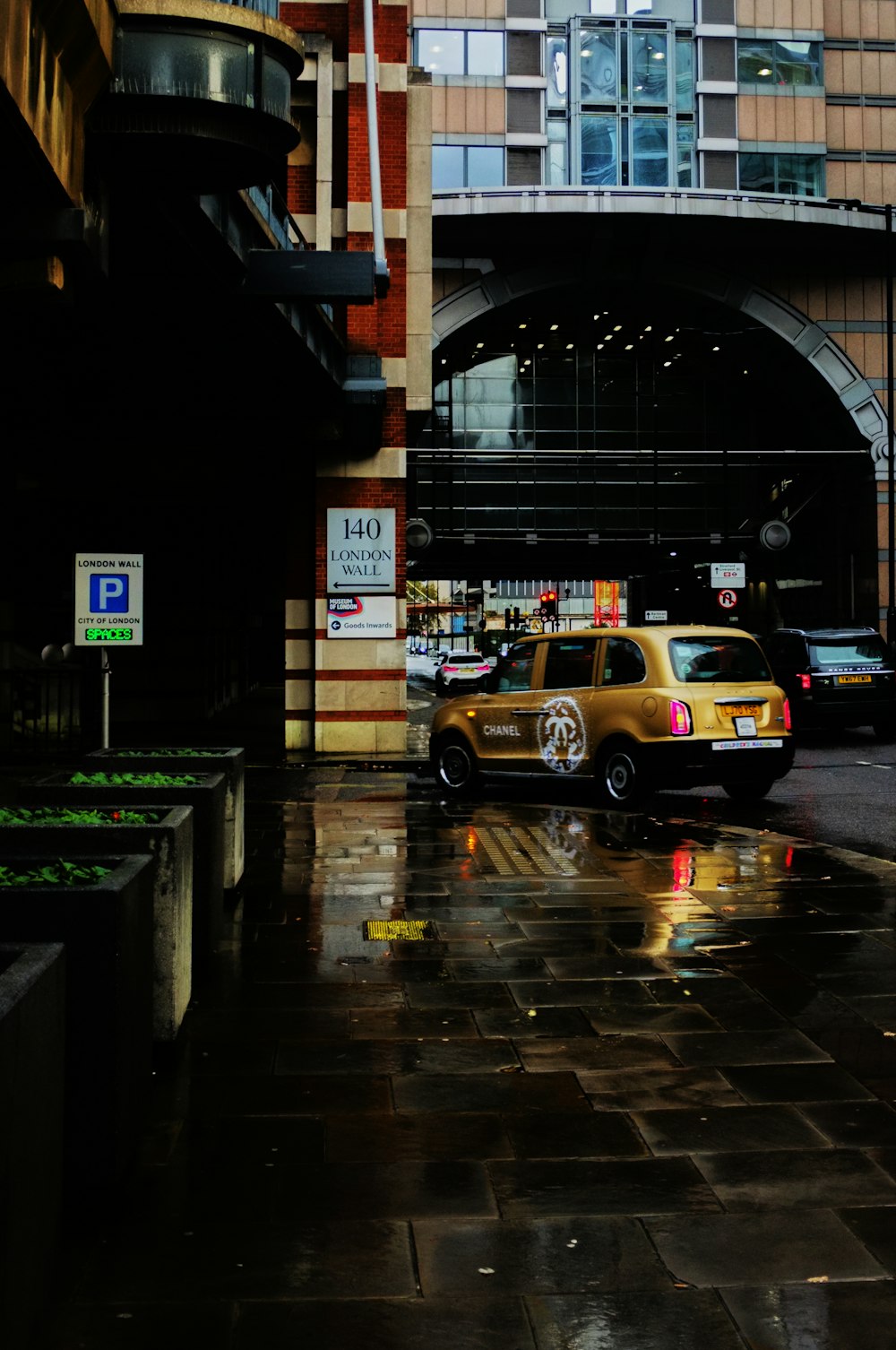 a yellow taxi cab parked in front of a tall building