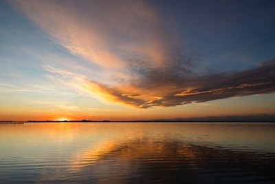 A sunset over calm waters, capturing the peaceful promise after emotional storms.