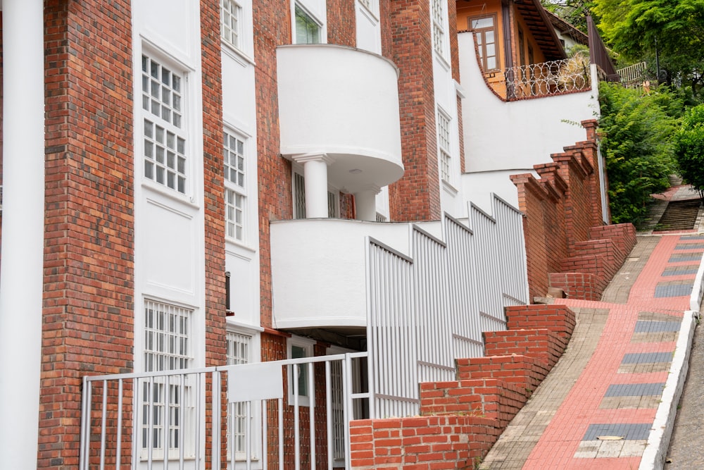 a white and red brick building with white balconies