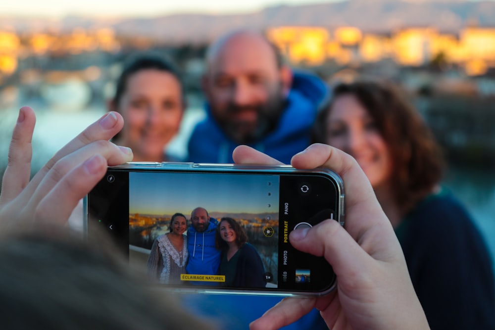 um grupo de pessoas tirando uma foto com um celular