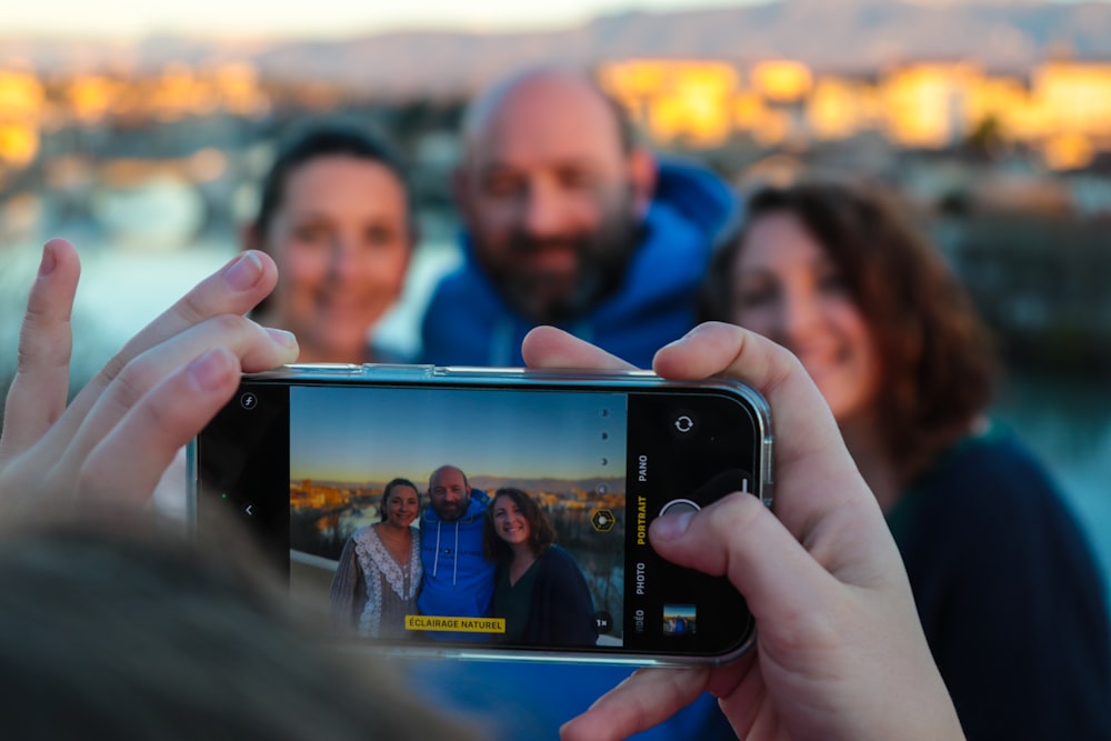 eine Gruppe von Menschen, die ein Foto mit einem Handy machen