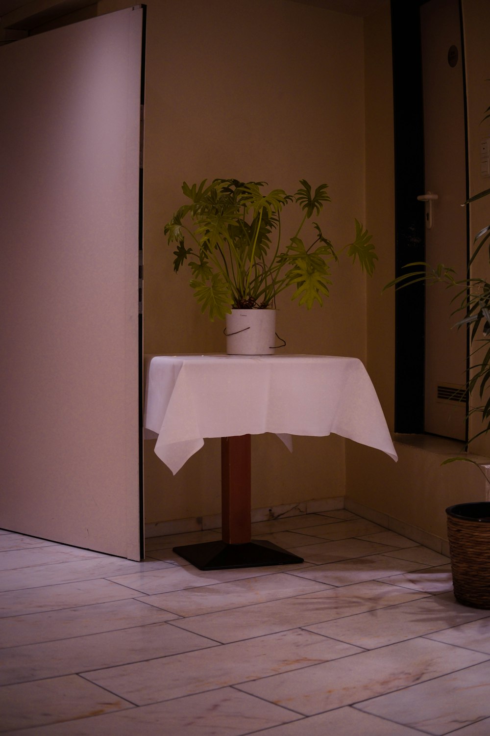 a table with a white table cloth and a potted plant
