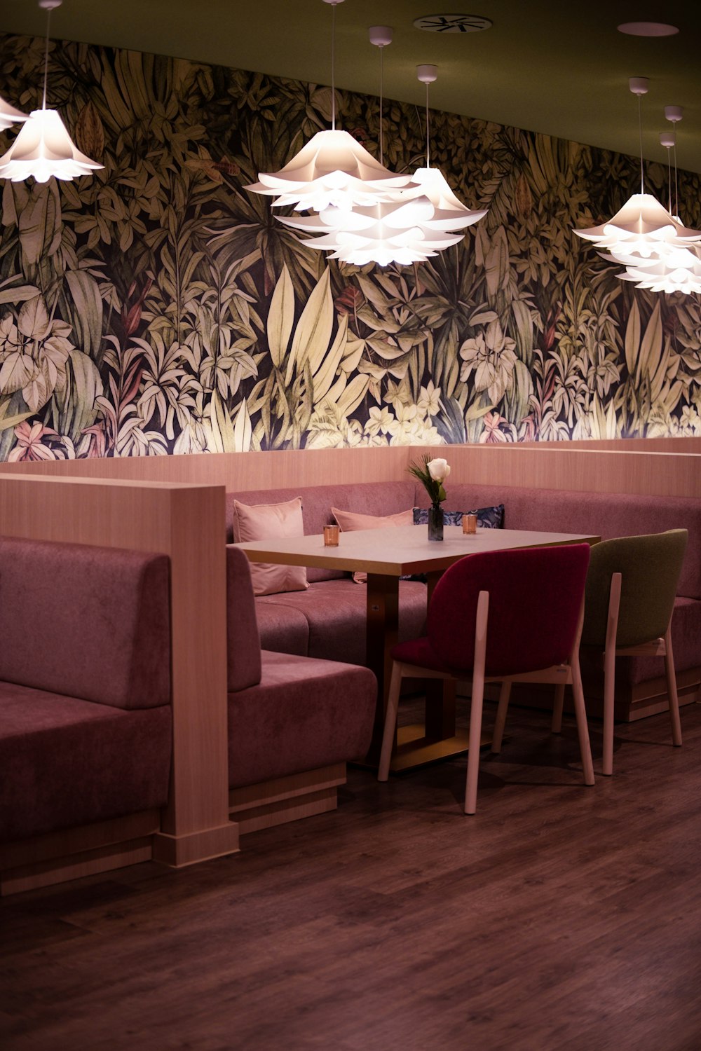 a restaurant with a wooden floor and a floral wallpaper