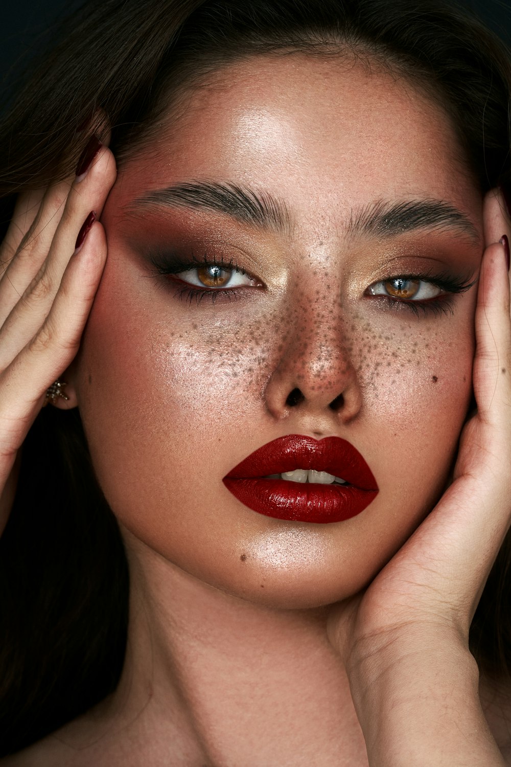 a woman with red lipstick and freckles on her face