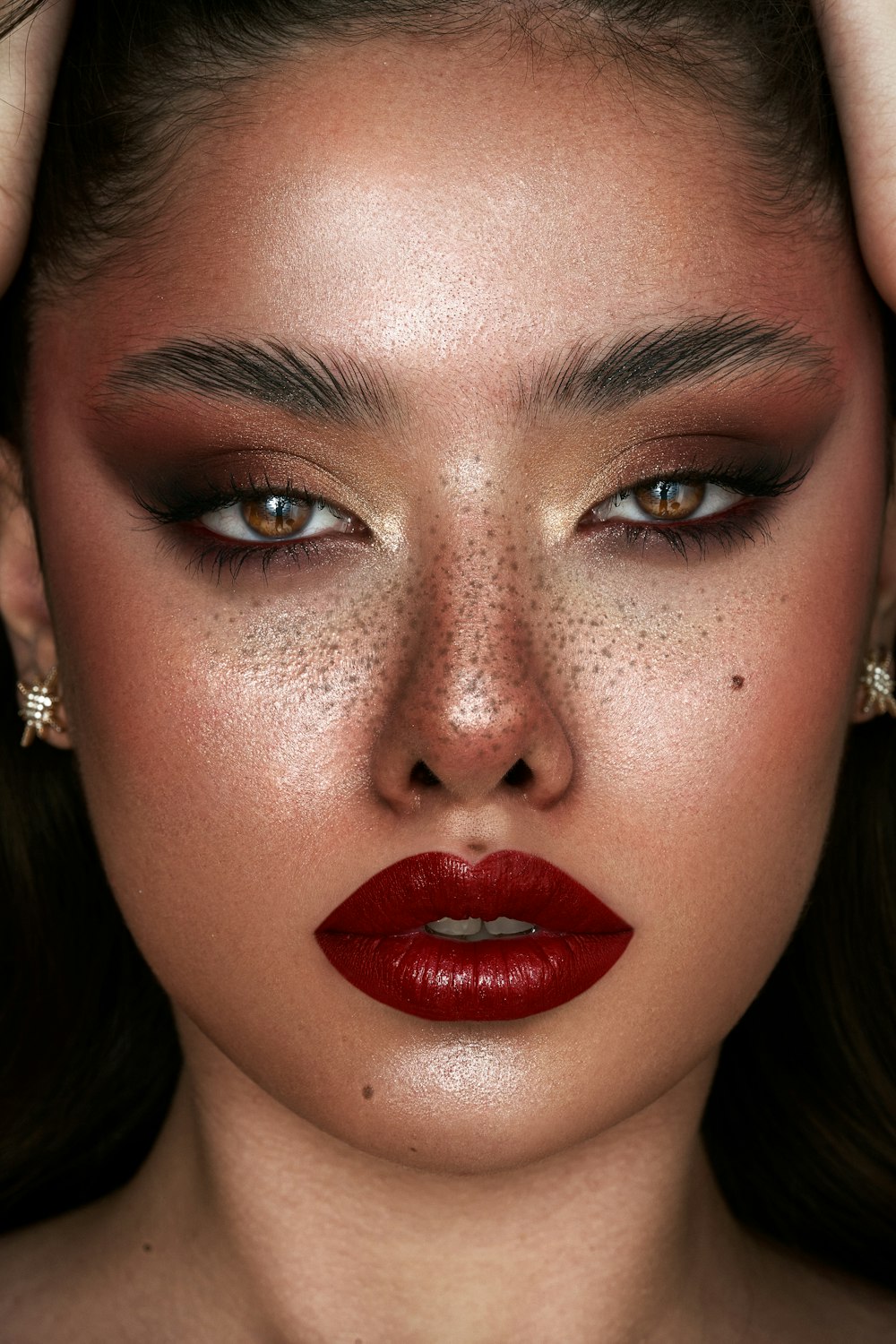 a woman with red lipstick and freckles on her face