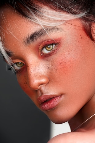 Close-up of artistic makeup highlighting natural features with warm lighting.