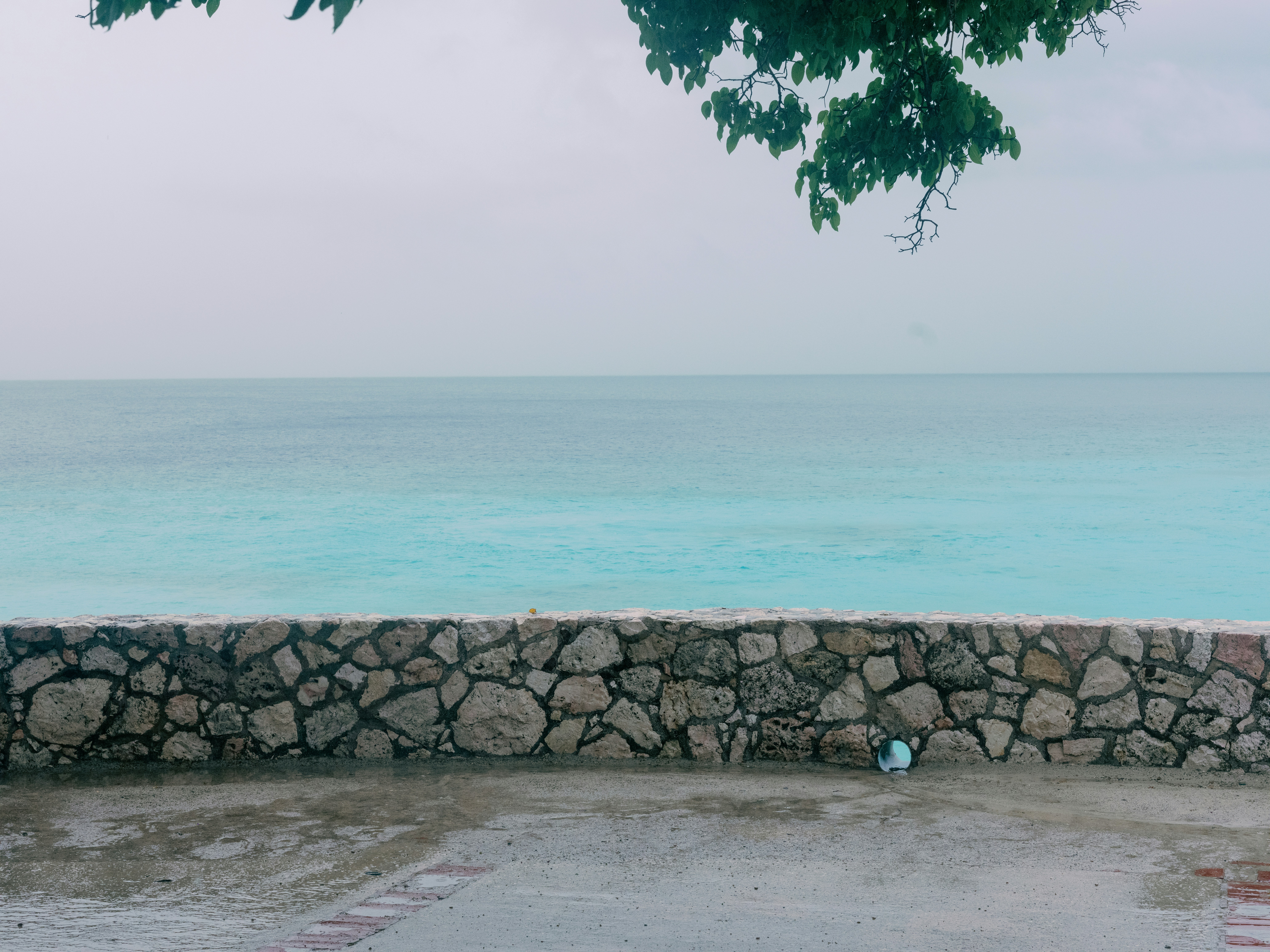 a stone wall next to a body of water
