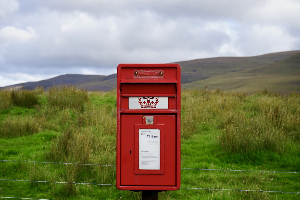 a red mailbox in a grassy field