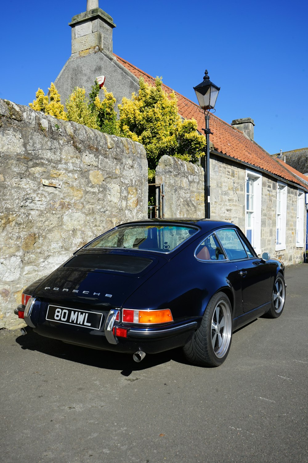 a black sports car parked in front of a stone building