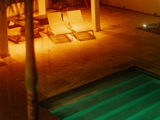 Close-up of a modern poolside lounge area with elegant lighting and comfortable seating.