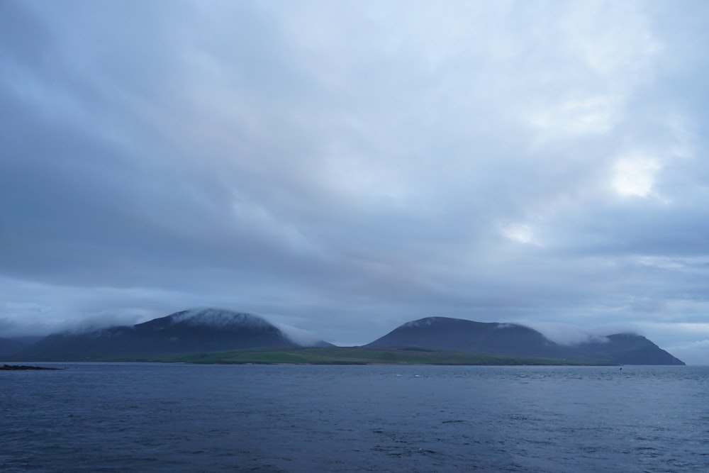 a large body of water with mountains in the background