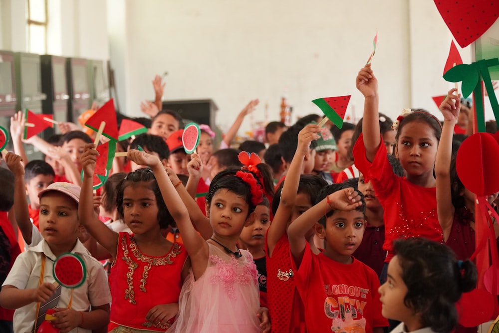 a group of children holding up flags in a room