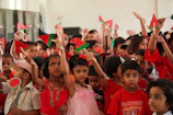 Smiling children proudly showing off their completed craft projects during a party.