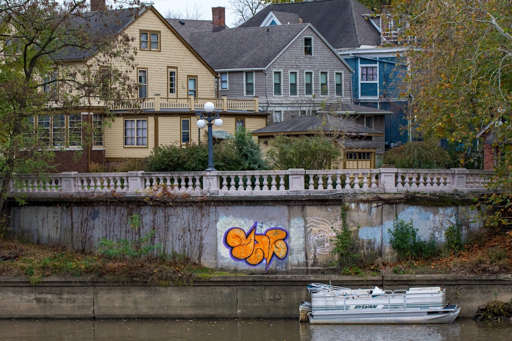 a white boat floating on top of a river next to a bridge