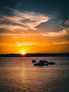 A stunning sunset over the Tanguar Haor wetlands with boats in the foreground.