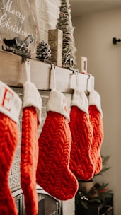 Classic red and white Christmas stockings hanging neatly on a mantelpiece, ready for festive surprises.