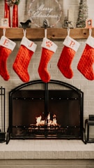Eco-friendly Christmas stockings hanging by a fireplace, decorated with cheerful patterns.