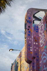 An artist painting a vibrant mural in an urban setting, captured in natural light.