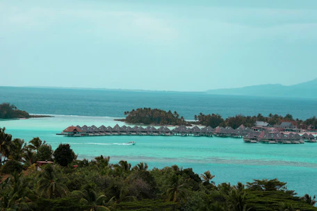 A serene overwater villa with turquoise waters and lush greenery.