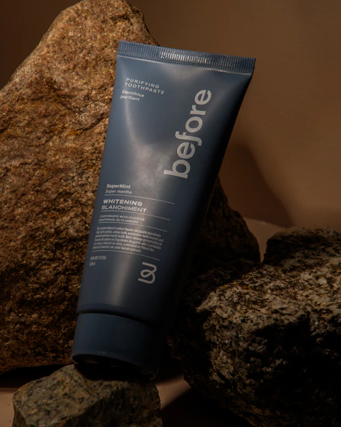 Close-up of a fresh, minty Shinex toothpaste tube with a bright smile in the background