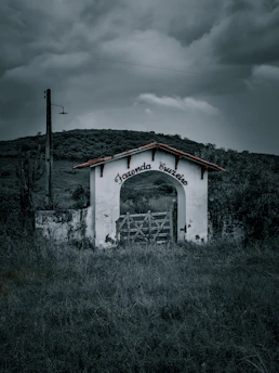 Farm entrance sign with the name 'Natan Feliciani Merizio' surrounded by trees.