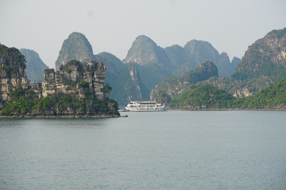 a boat on a large body of water surrounded by mountains