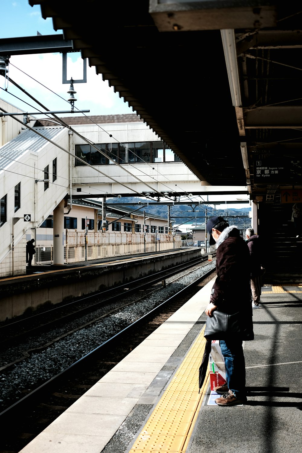 a group of people waiting for a train at a train station