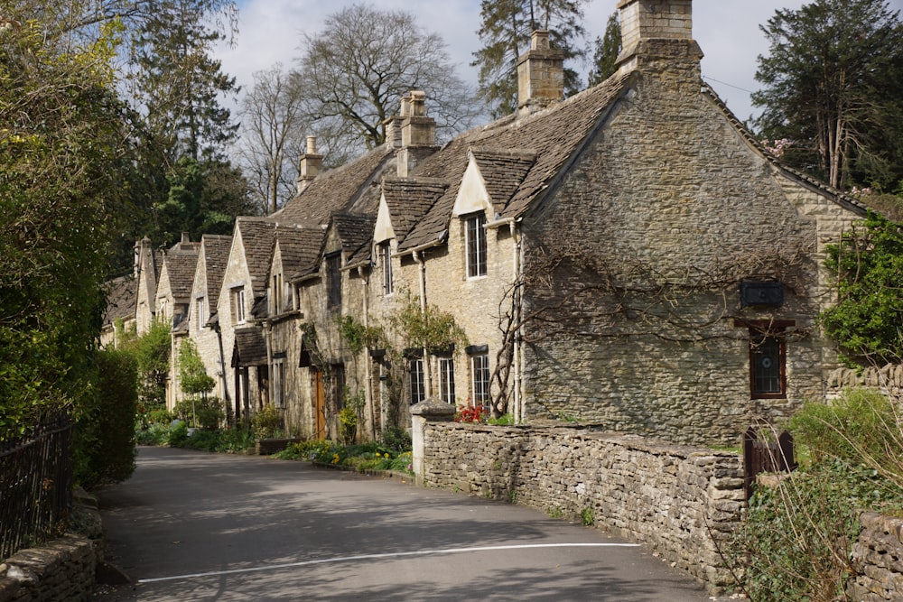 a street lined with stone houses next to trees